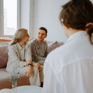 A couple sits on a couch across from a therapist.